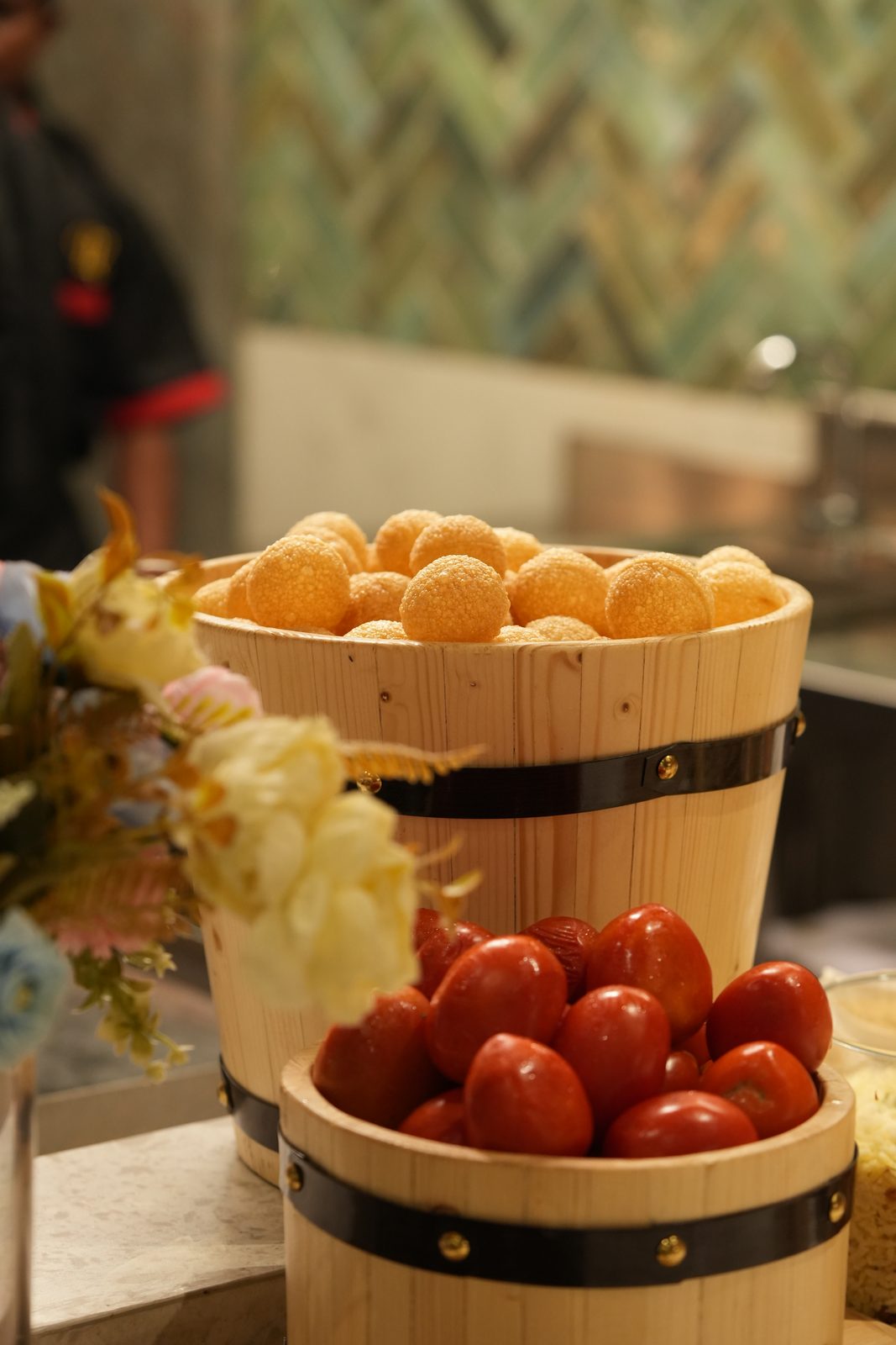 Baskets of pani puri shells and tomatoes at the chaat station