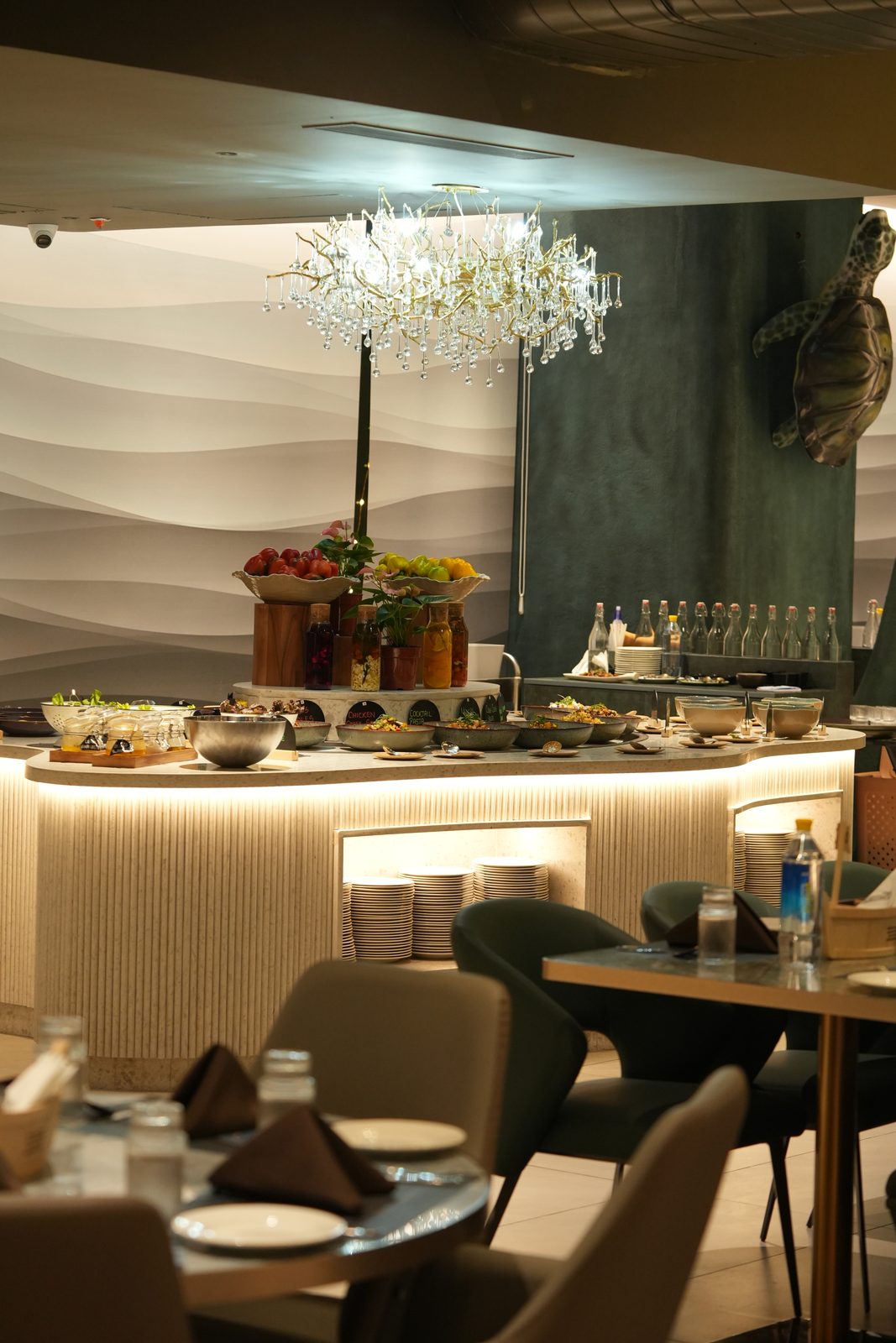 Tables set around the central buffet island and chandelier
