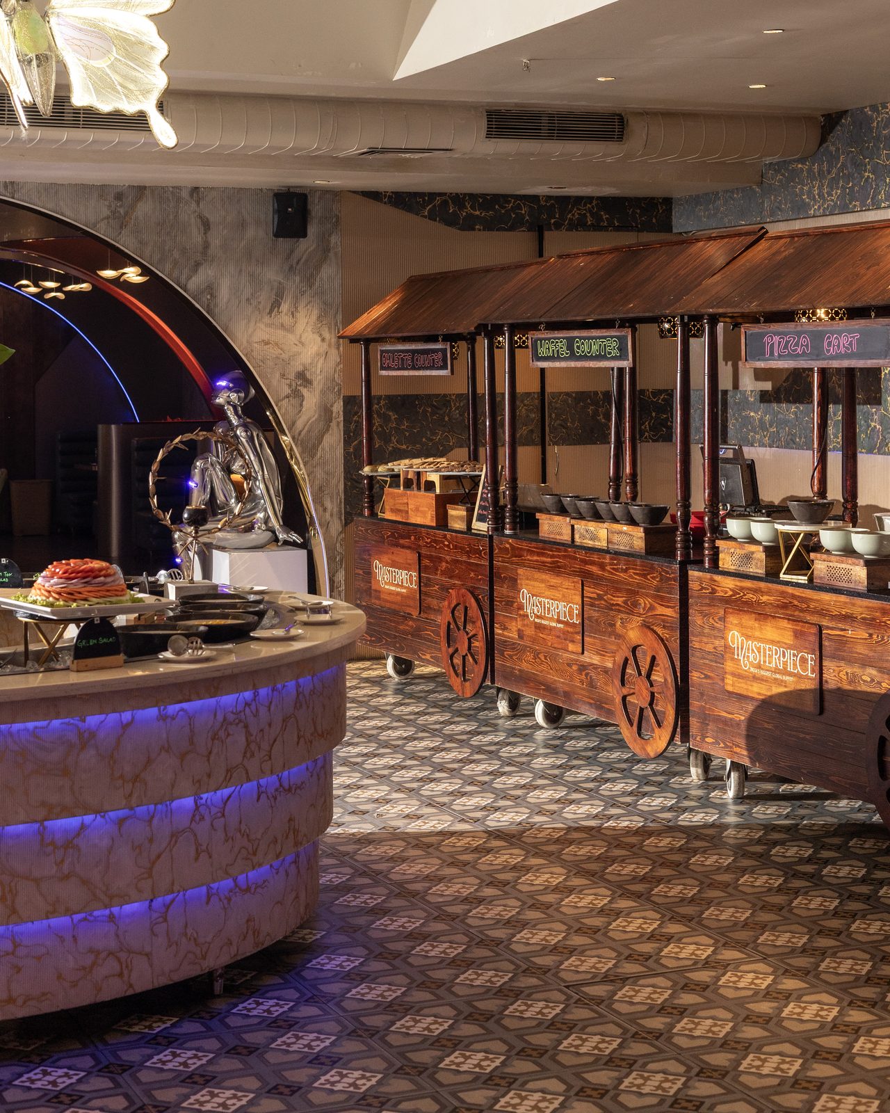 Wooden live-station carts and a lit round counter in the dining hall